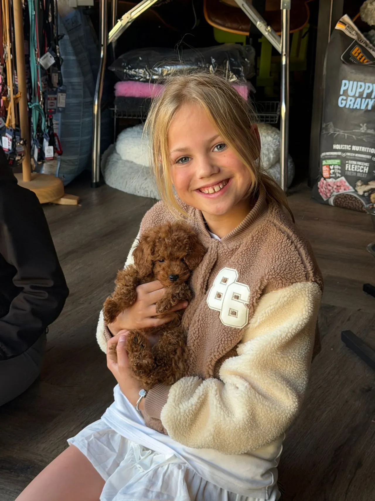 Lachend meisje met een rode pup in haar armen