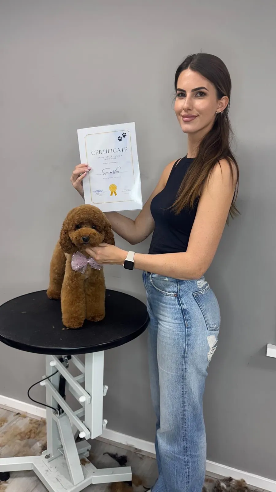 Serra met haar certificaat Asian Style en een getrimde rode toypoodle op de trimtafel